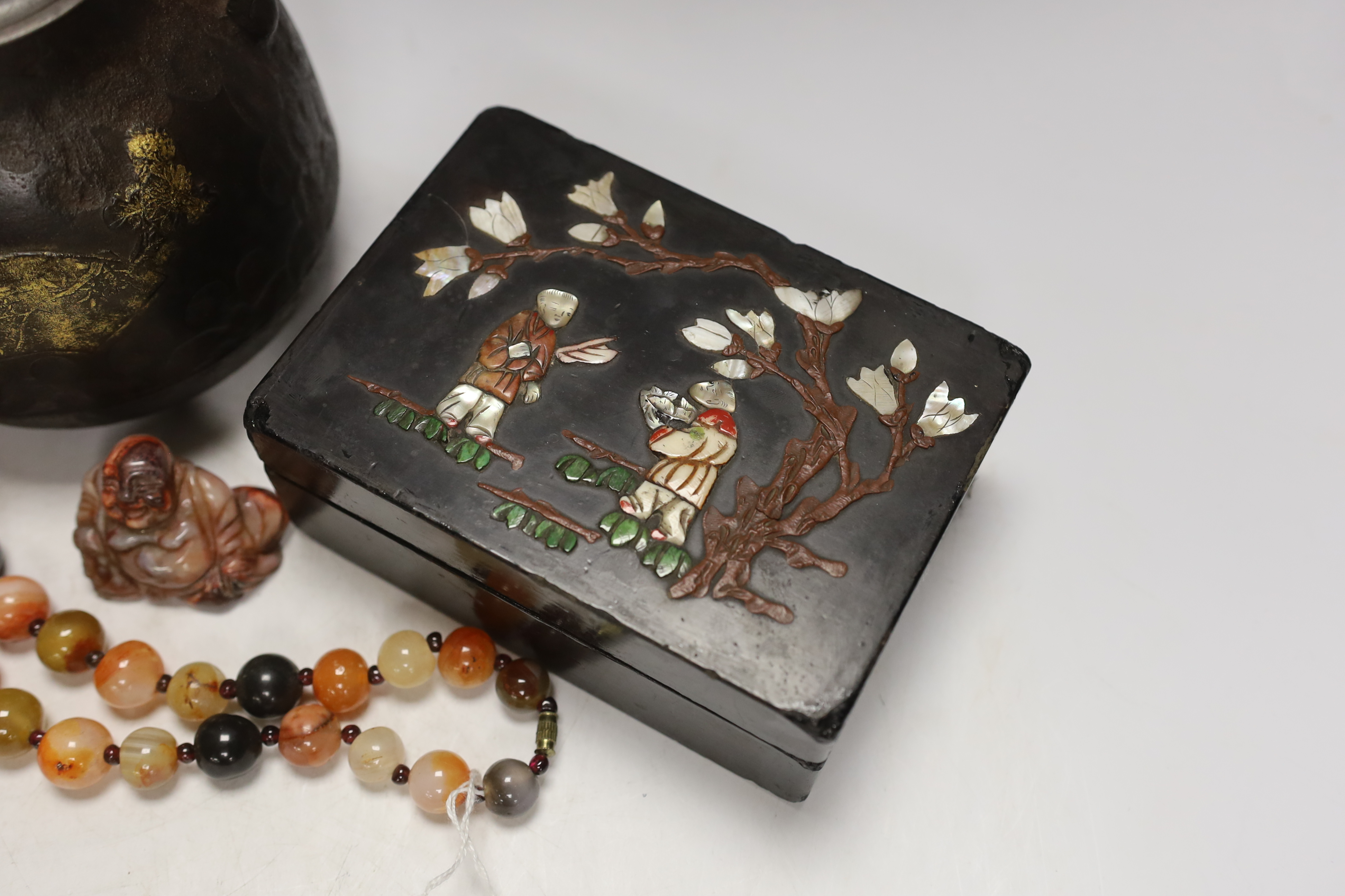 A Japanese iron tetsubin kettle with gilt decoration, a pair of Chinese cloisonné enamel vases, 12.5cm, a lacquered box with mother of pearl inlay, a carved black stone disc, 5cm diameter, a miniature ceramic pot and an